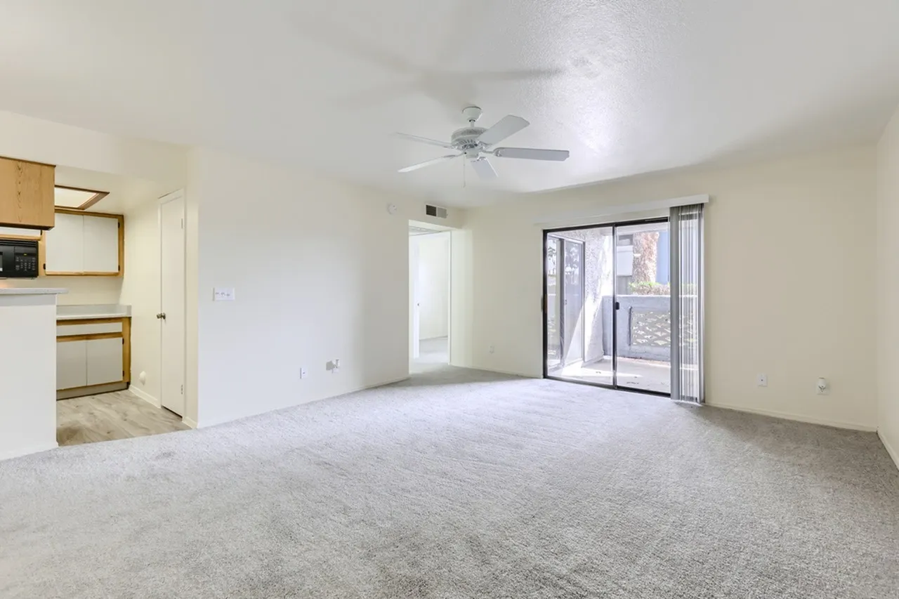A1 Classic living room, ceiling fan, carpet flooring, sliding glass door to patio