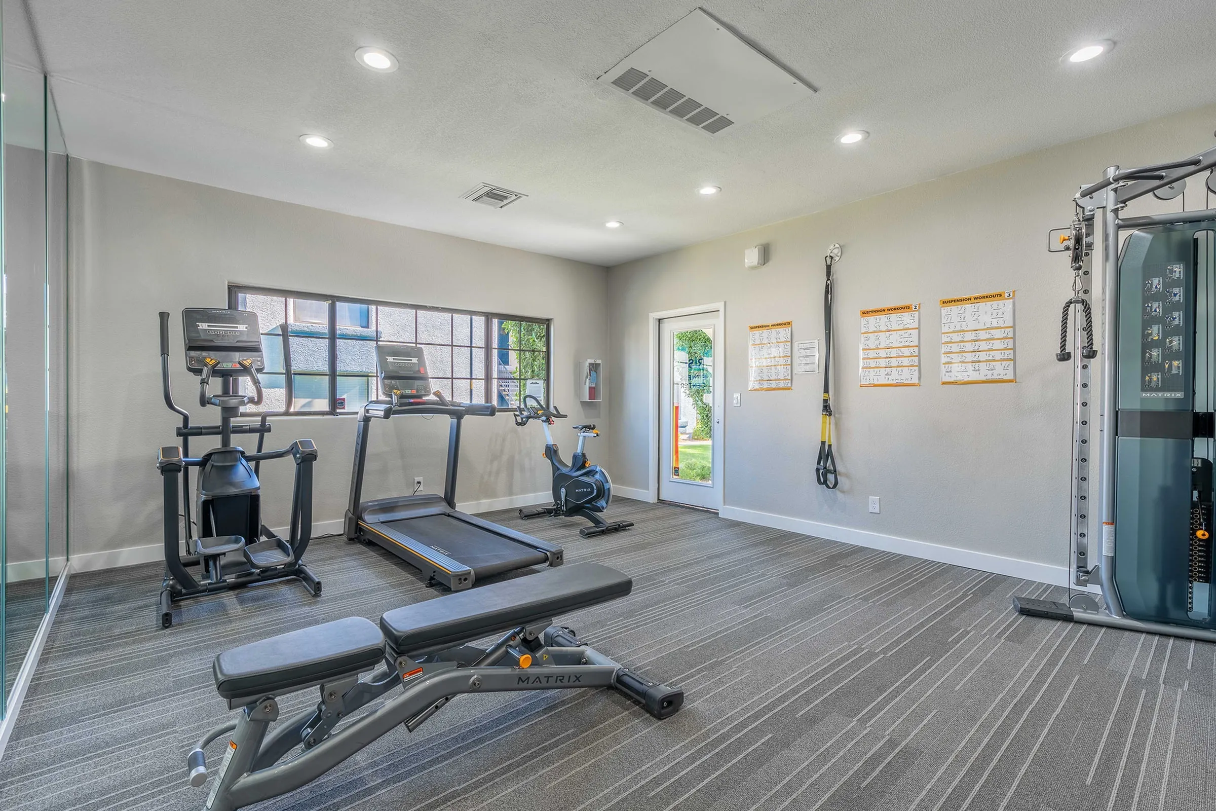 Fitness center, treadmills, bench, exterior windows, entry door