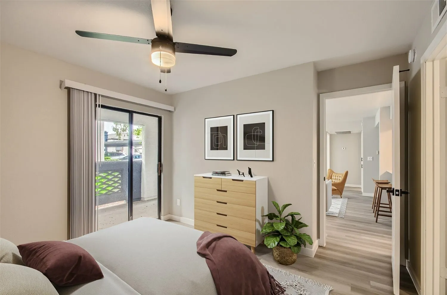 Primary bedroom, ceiling fan, sliding glass door to patio, wood-style plank flooring