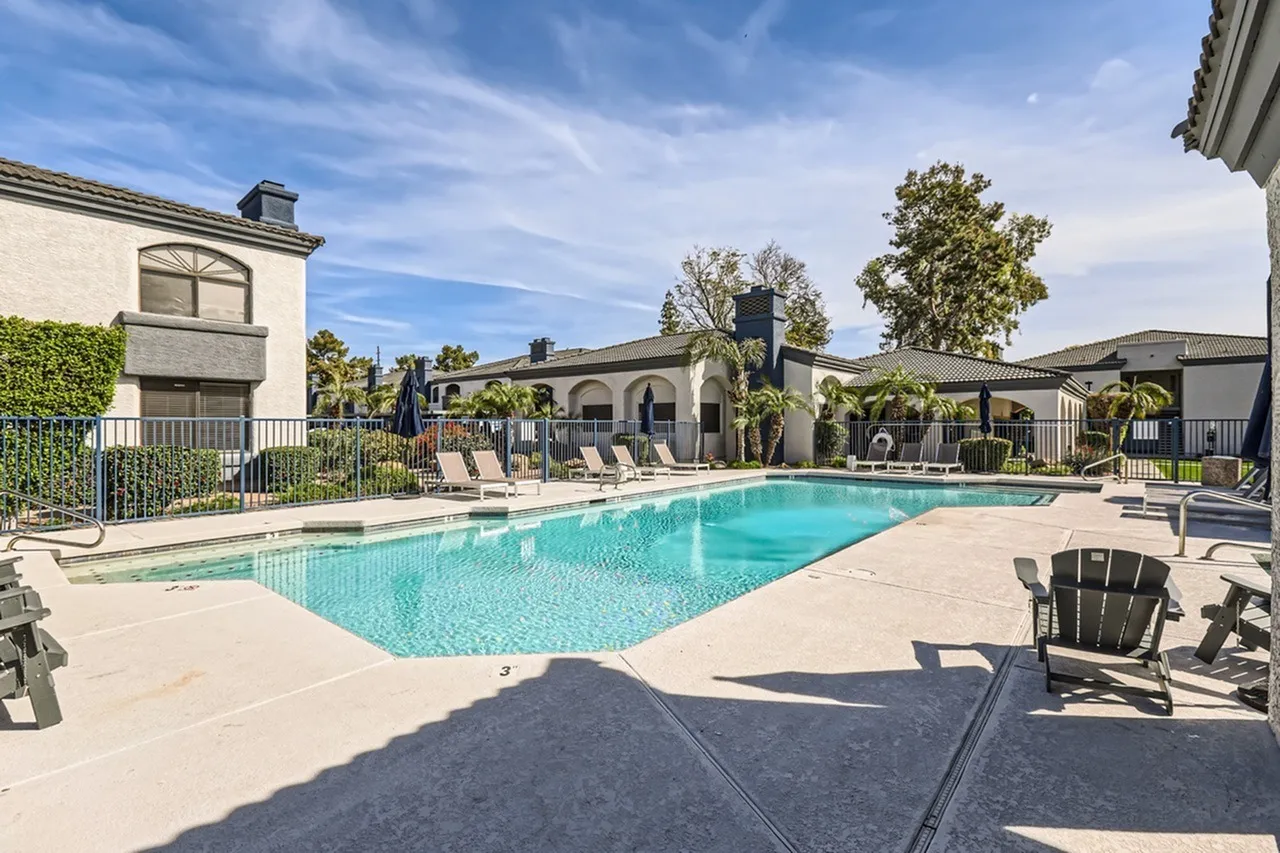 Sparkling pool, pool deck, lounge seating, building exterior, mature trees
