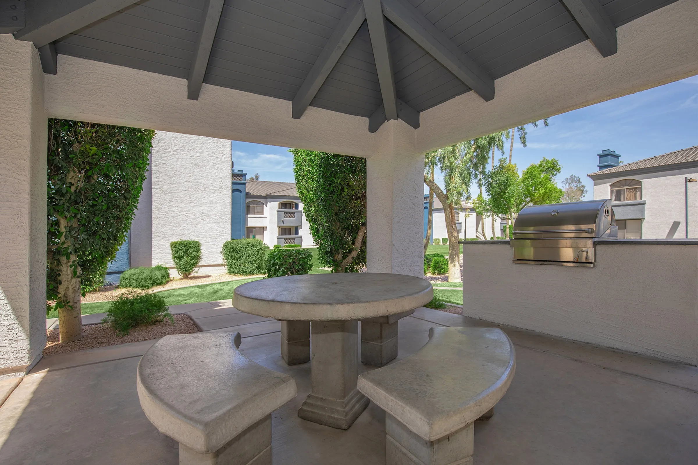 Covered picnic area, round table, built-in barbecue grill, landscaped courtyard