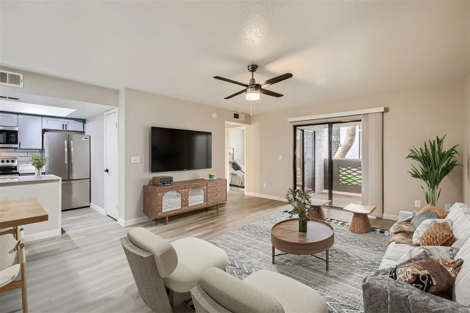 A1 Platinum living room, ceiling fan, wood-style plank flooring, sliding glass door to patio