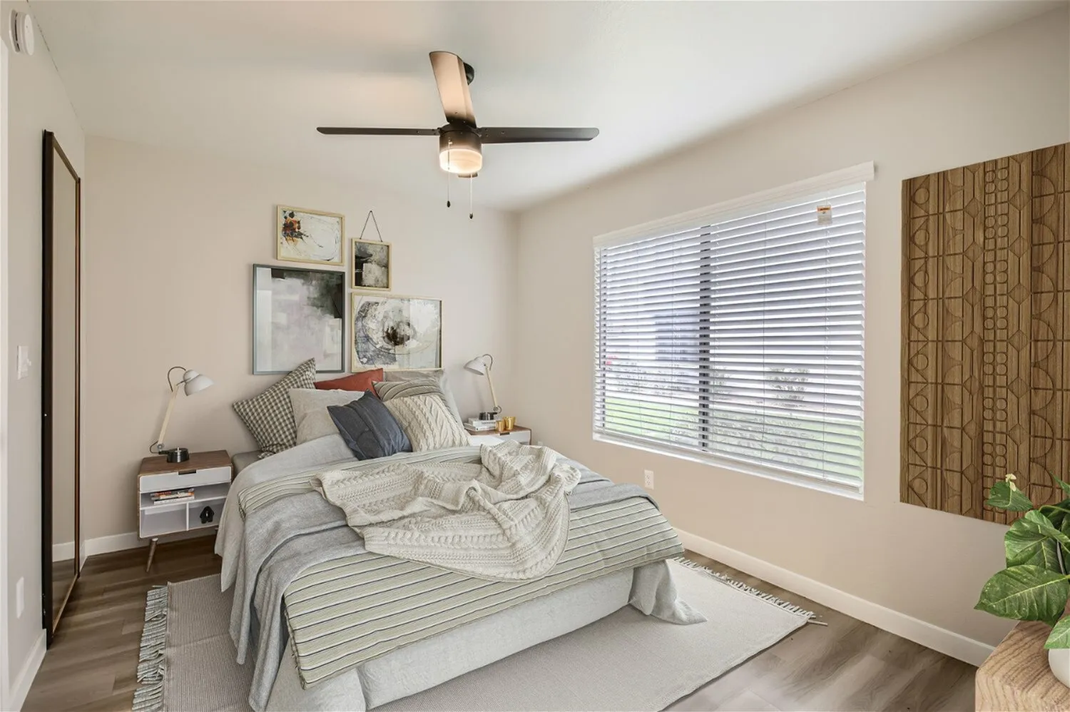 Bedroom, ceiling fan, large window with horizontal blinds, wood-style plank flooring