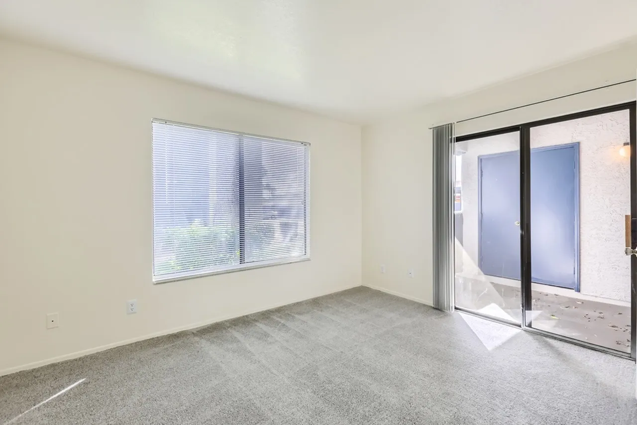 Bedroom, window with horizontal blinds, carpet flooring, sliding glass door