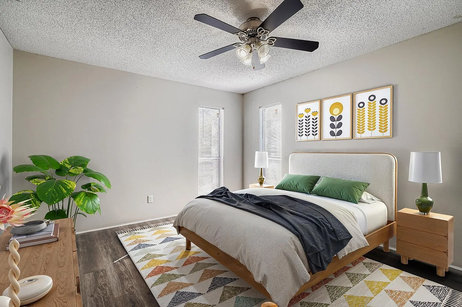 Primary bedroom, wood-style plank flooring, ceiling fan, green accent pillows