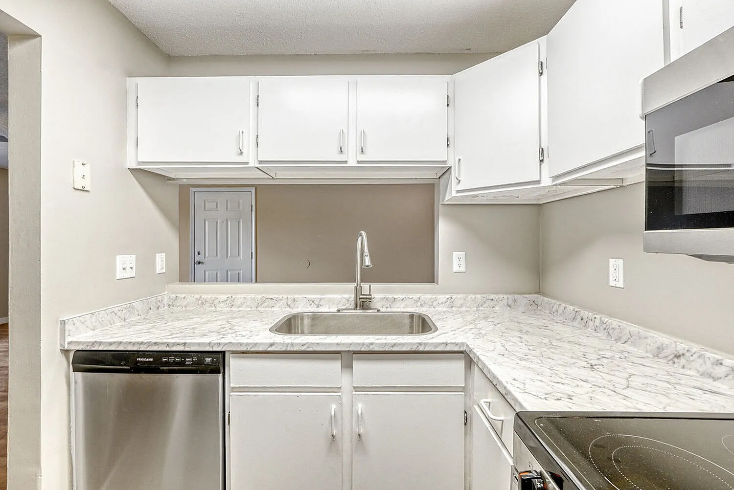 Kitchen, white shaker cabinetry, marble countertops, stainless appliances, single sink