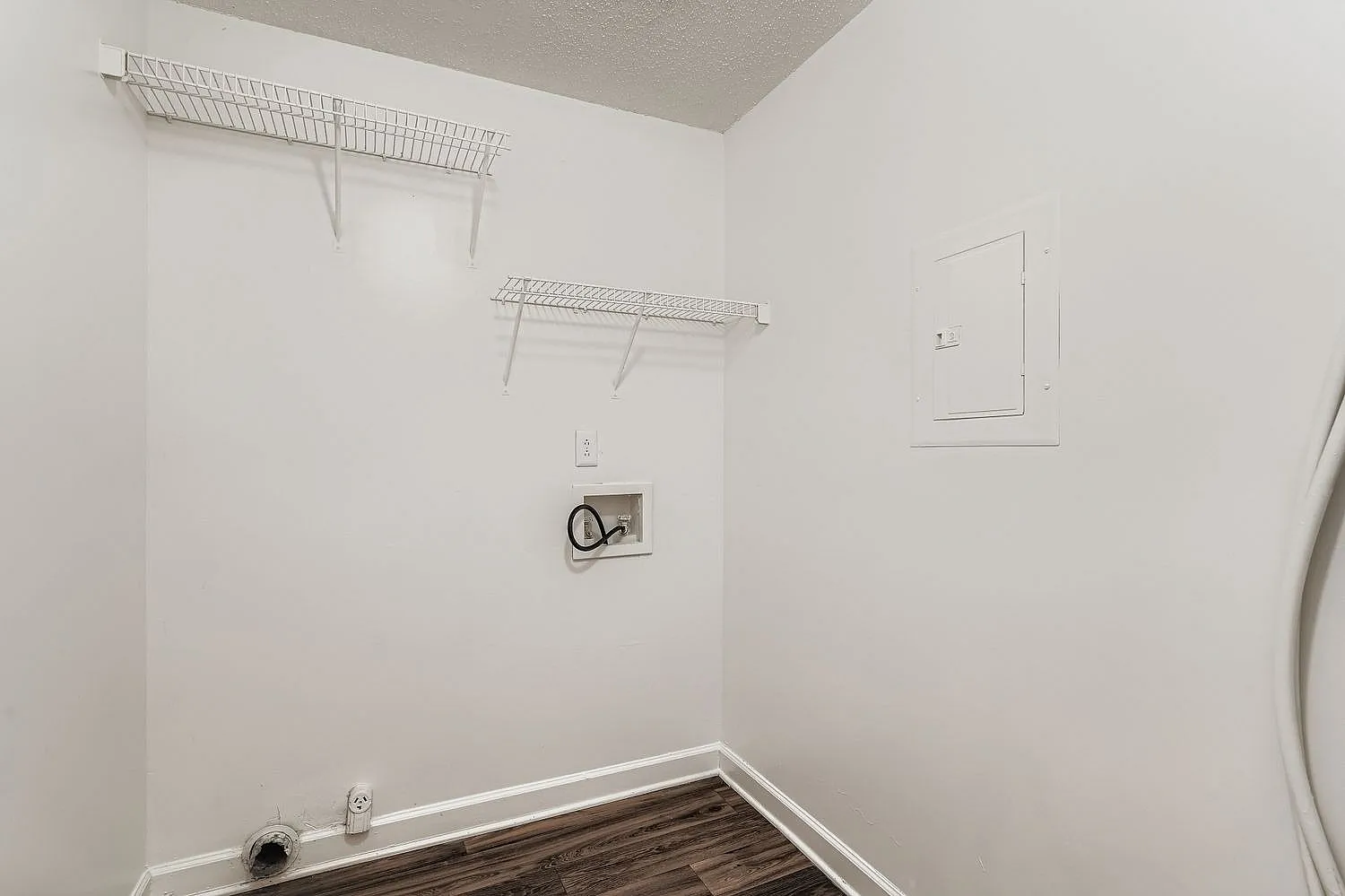 Laundry room, wire shelving, wood-style plank flooring, washer hookups, white walls