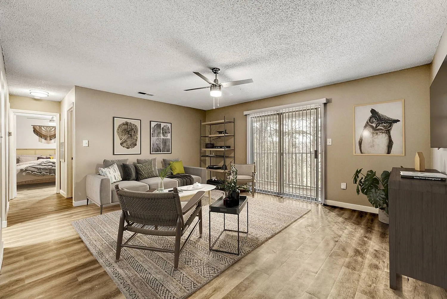 Living room, wood-style plank flooring, ceiling fan, neutral upholstered sofa, glass sliding doors