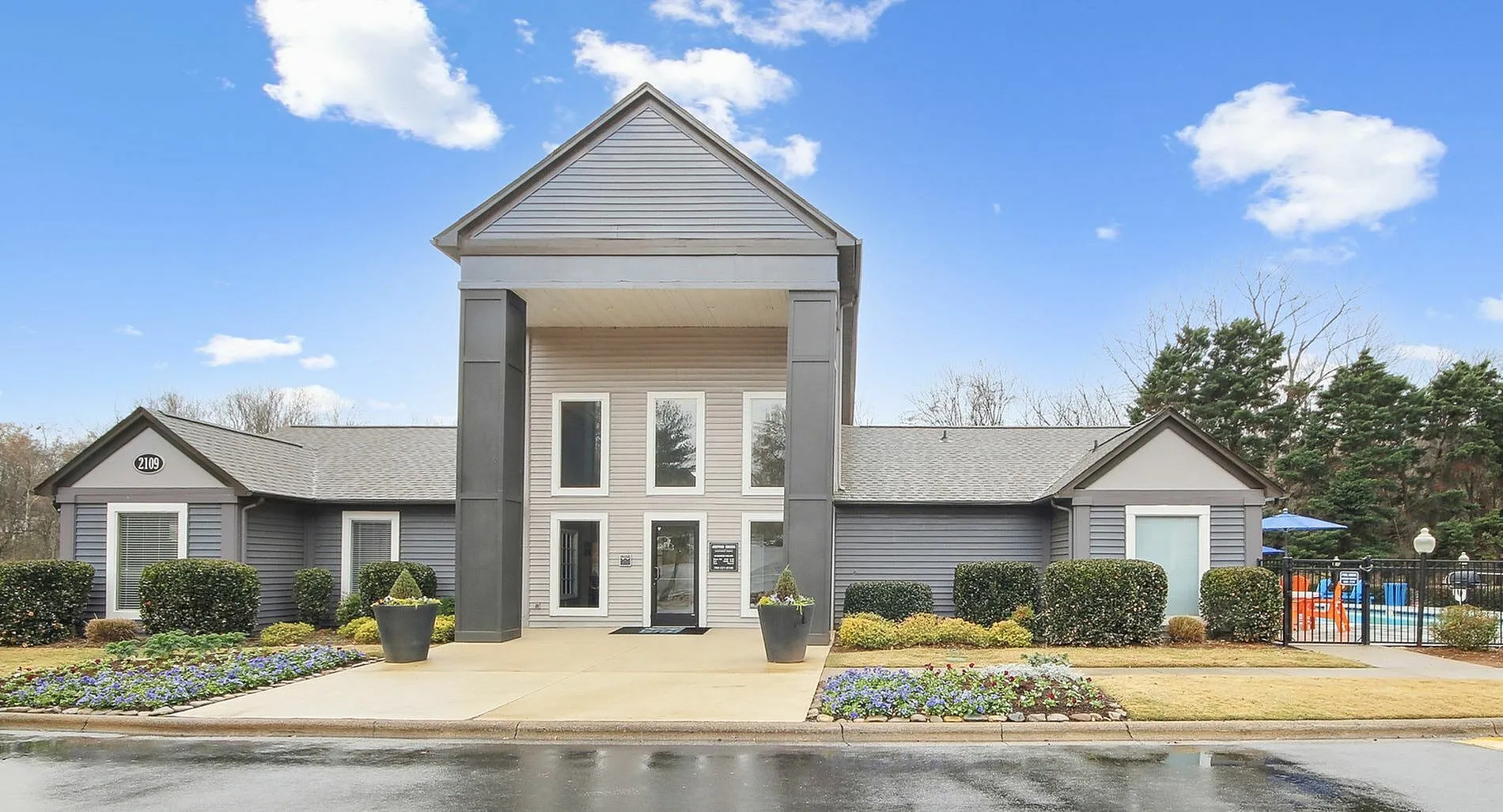 Community center exterior, white siding, peaked roof entry, manicured landscaping, Charlotte