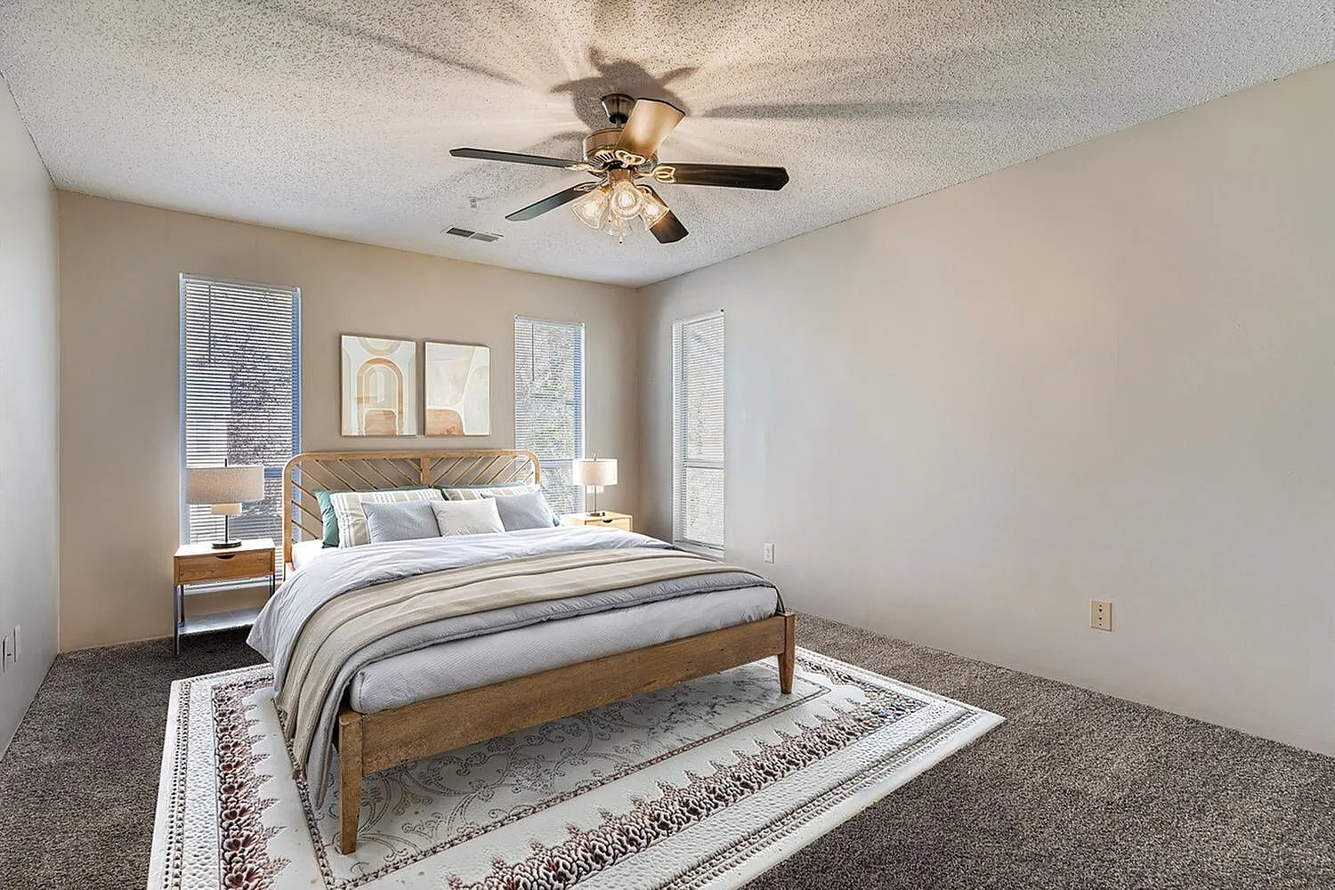 Primary bedroom, wood-style plank bed frame, ceiling fan with lights, patterned area rug