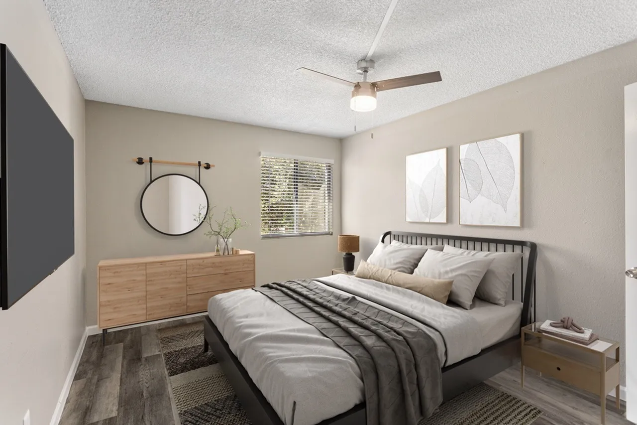 Primary bedroom, black metal bed frame, wood-style plank flooring, wooden dresser, ceiling fan