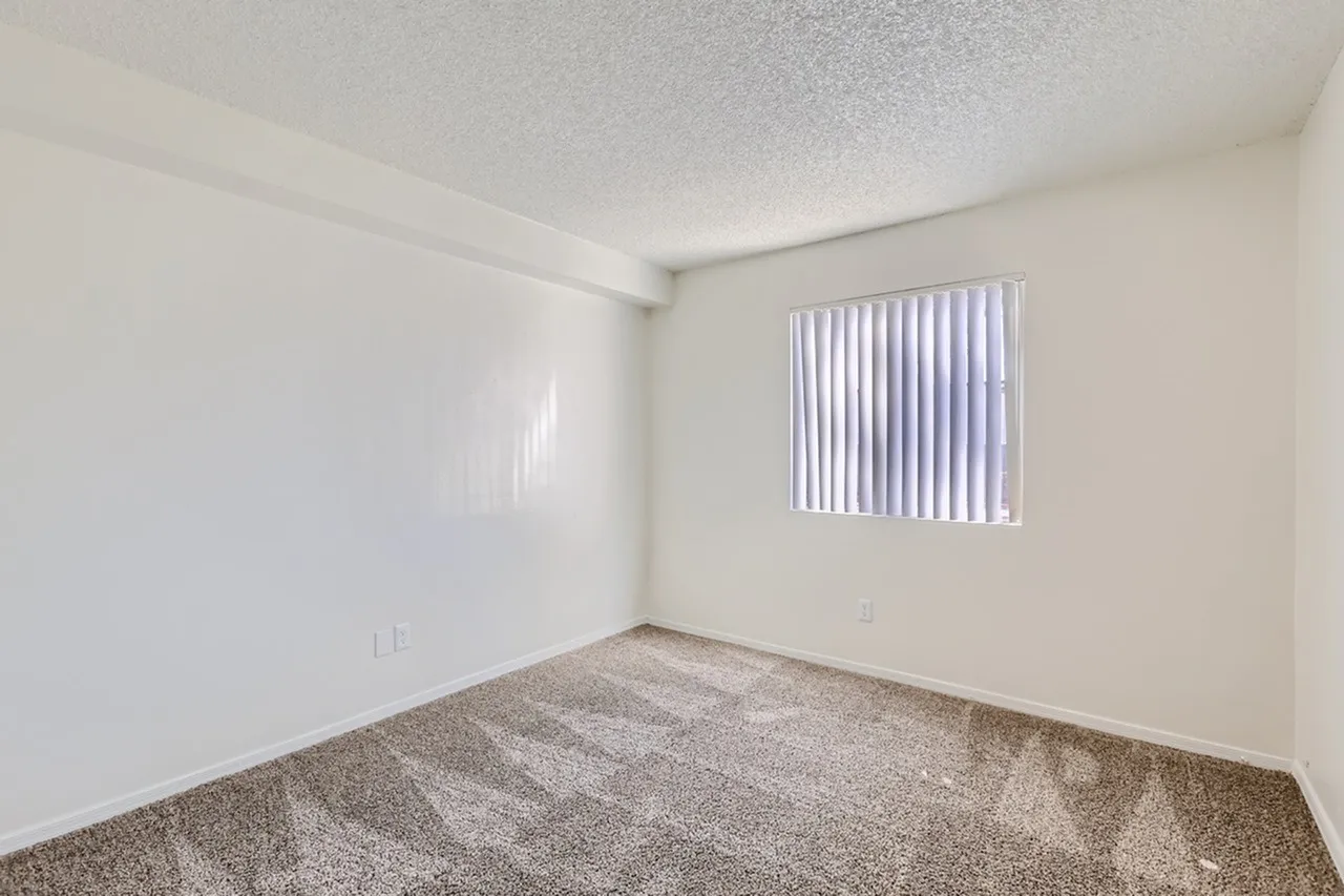 Bedroom, carpet flooring, vertical blinds, white walls, textured ceiling