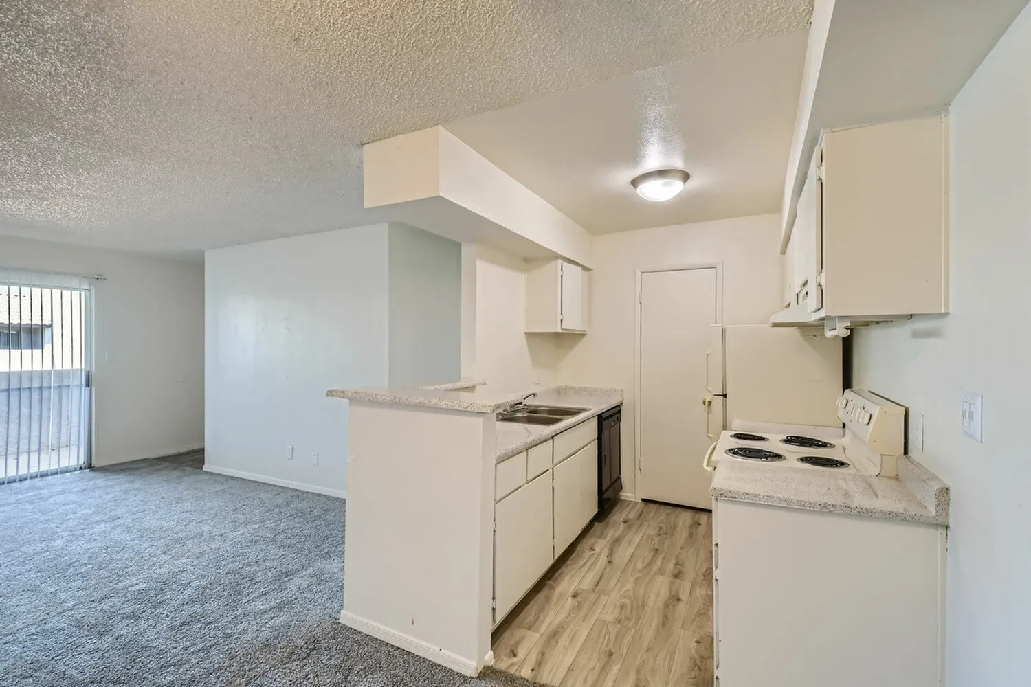 Kitchen, white cabinetry, electric range, wood-style plank flooring, open floor plan