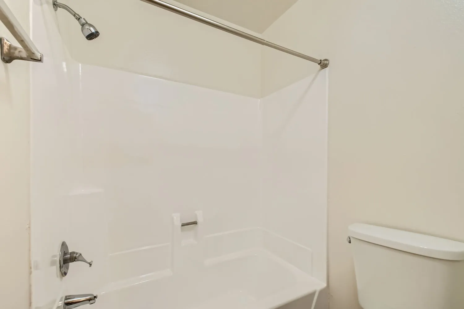 Bathroom, white subway tile surround, chrome showerhead, soaking tub, toilet