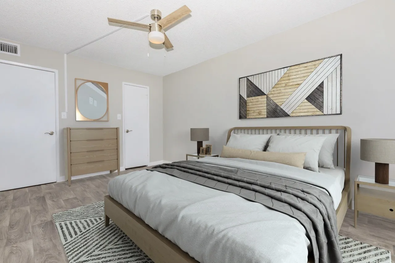 Primary bedroom, wood-style plank flooring, upholstered bed frame, wood-look nightstands, ceiling fan