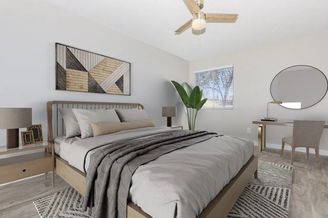 Primary bedroom, wood-style plank flooring, ceiling fan, geometric wall art, round mirror