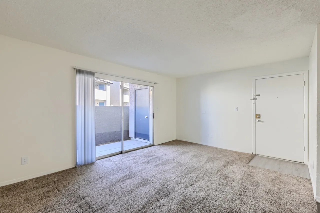 Living room, carpet flooring, sliding glass patio doors, white entry door
