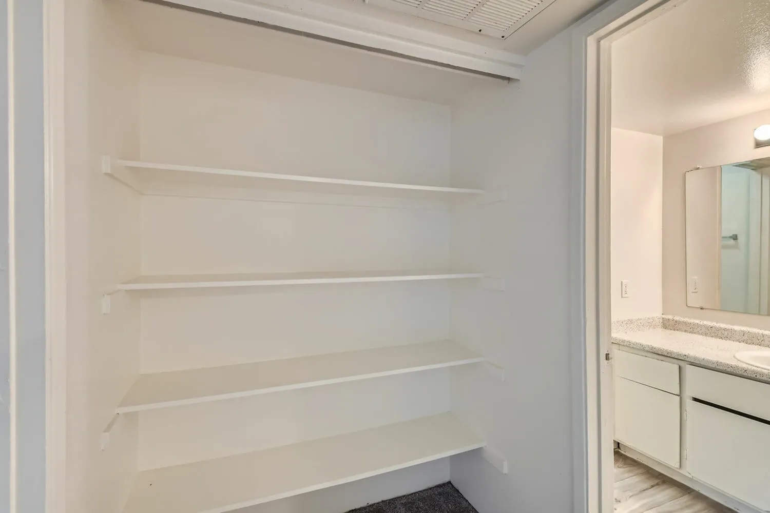 Bathroom nook, white built-in shelves, white vanity, large mirror