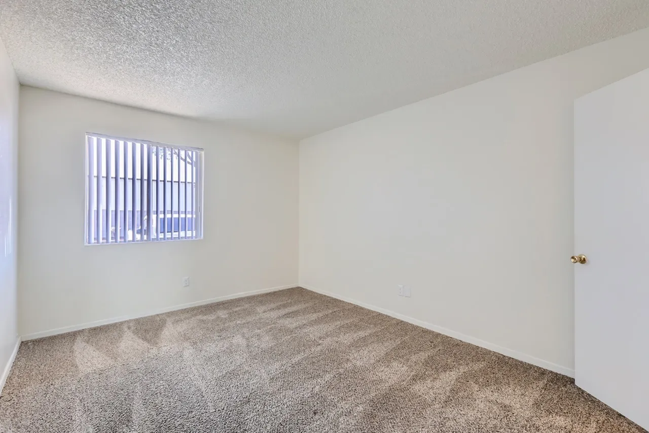 Bedroom, carpet flooring, vertical blinds window, textured ceiling