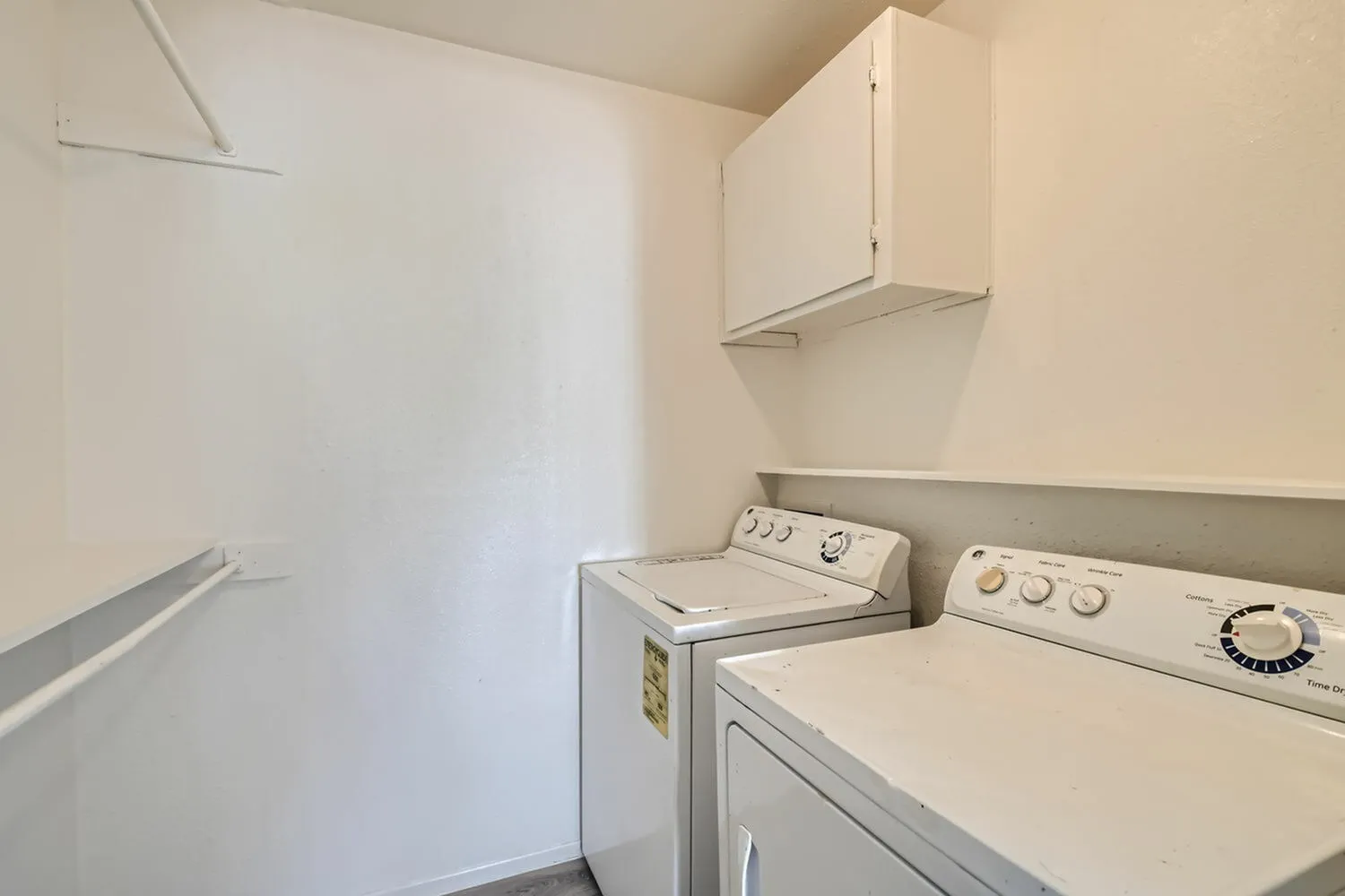 Laundry room, washer and dryer appliances, white cabinetry, overhead storage, tile countertop