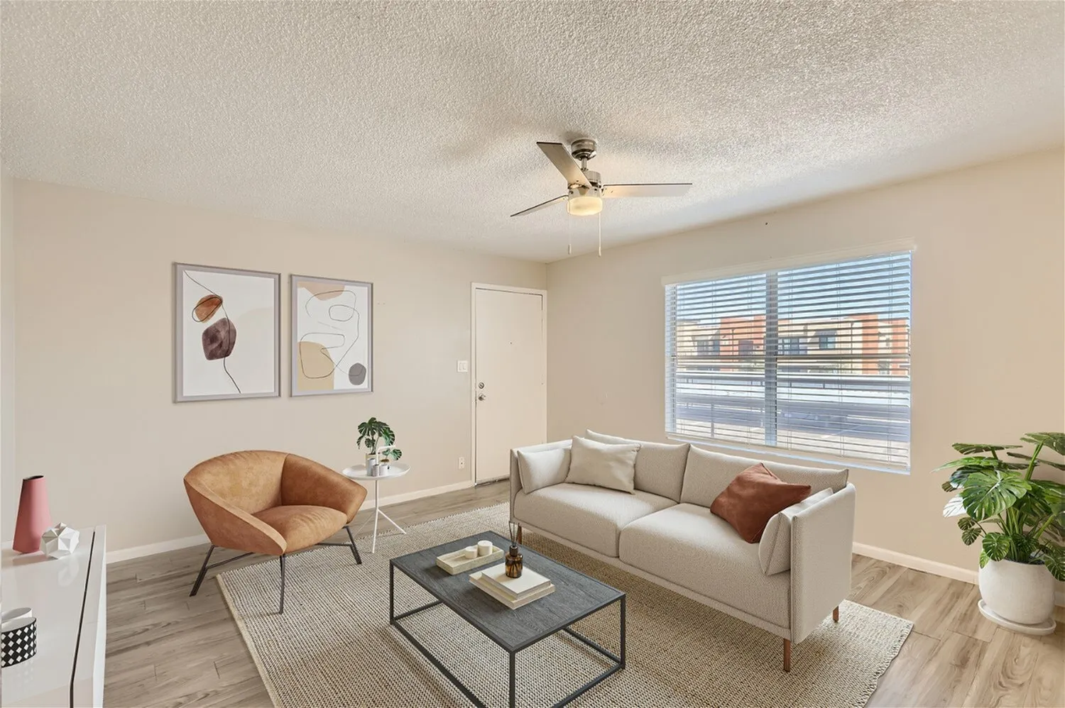 Living room with wood-style plank flooring, beige sofa, tan accent chair, ceiling fan, sliding glass doors