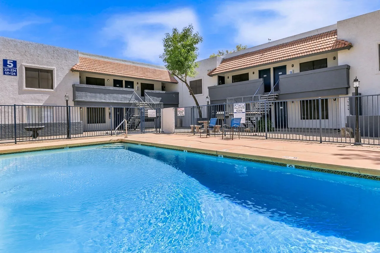 Resort-style swimming pool, terracotta tile roof buildings, metal railings, lounge seating, Glendale