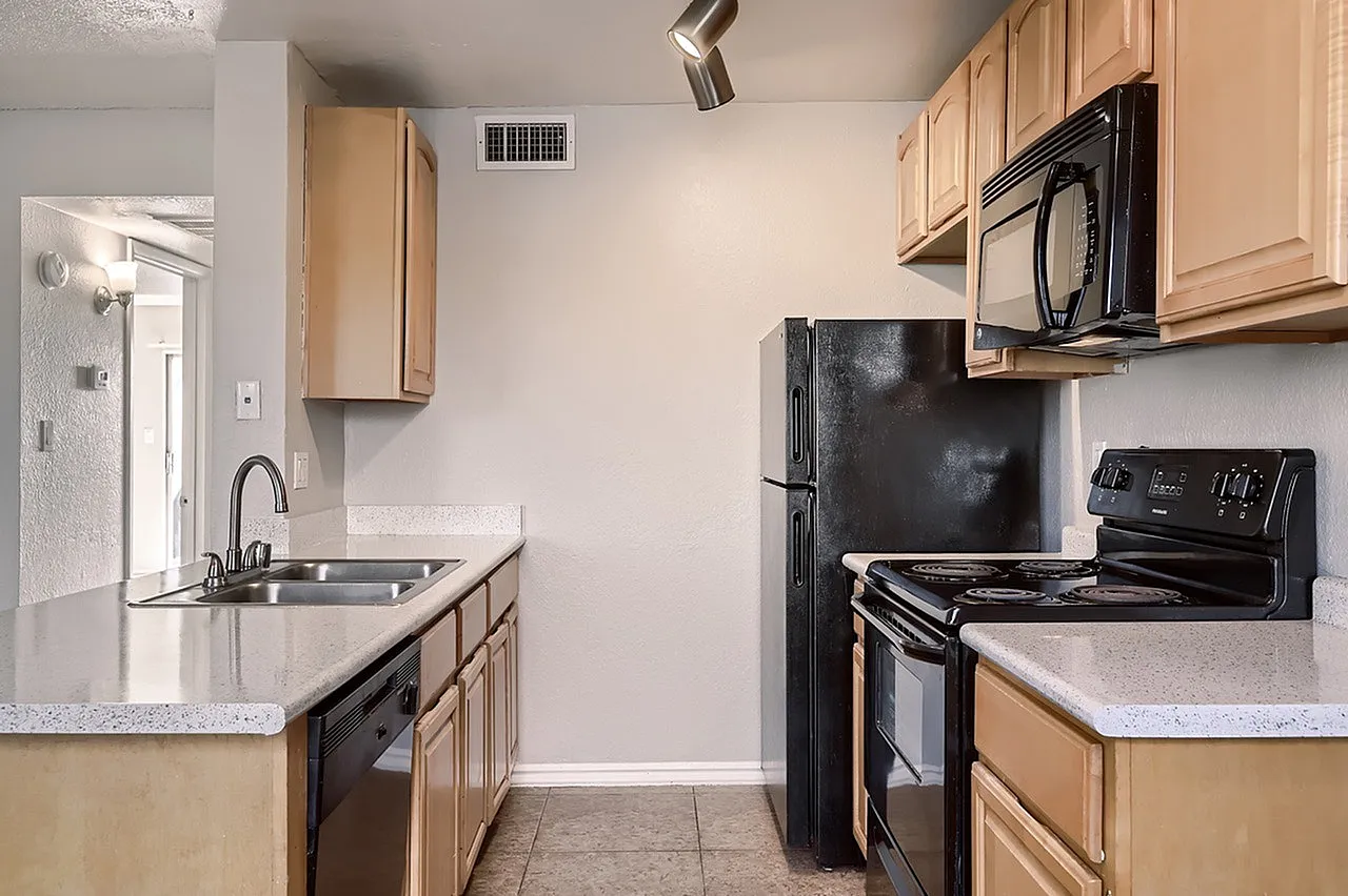 Kitchen, light wood cabinetry, quartz countertops, black stainless appliances, tile flooring