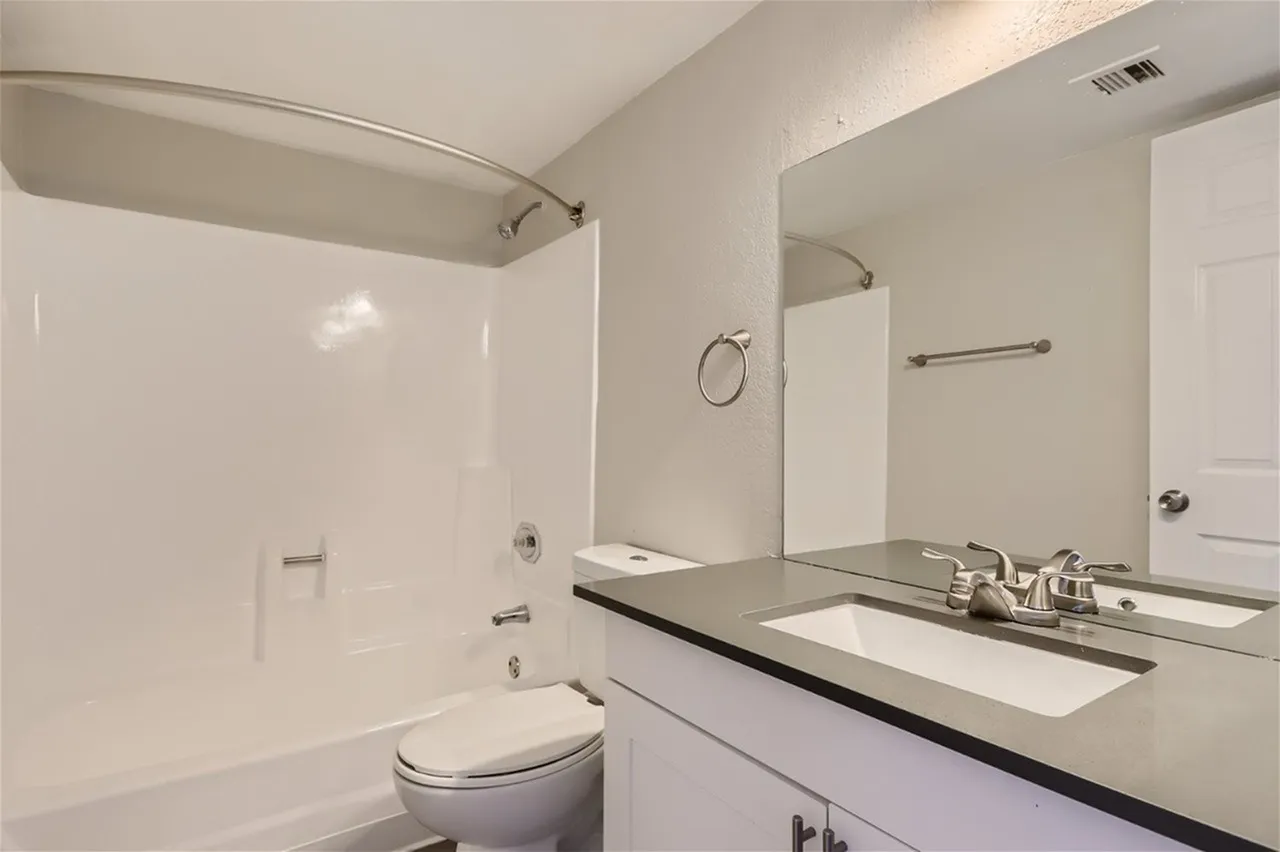 Bathroom, white cabinetry, quartz countertop, glass shower enclosure, toilet