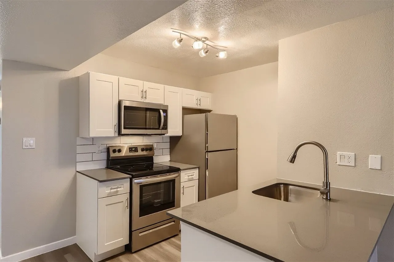 Kitchen, white shaker cabinetry, gray quartz countertops, stainless appliances, island sink