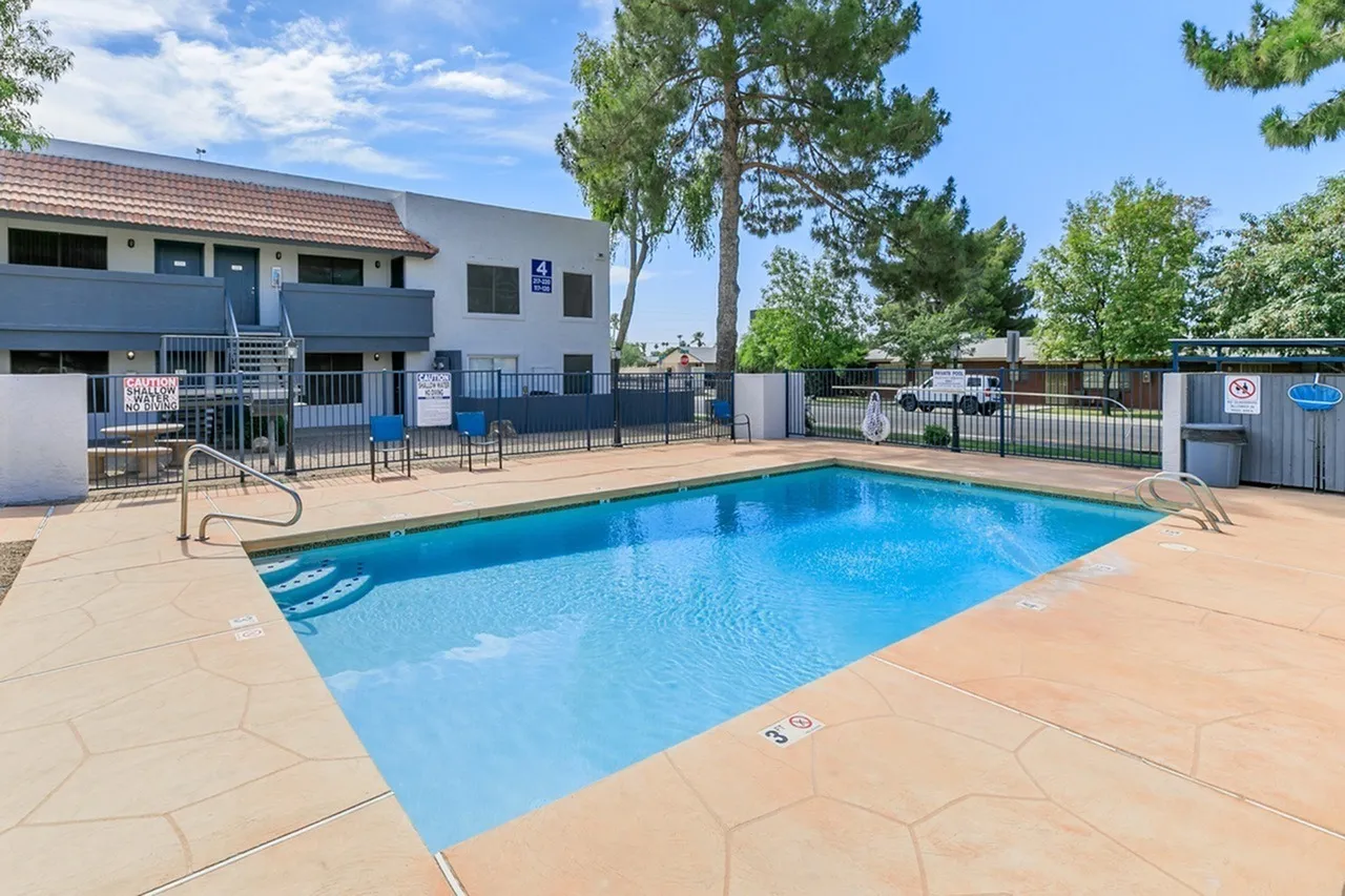 Swimming pool, concrete deck, black fencing, building, mature trees, Glendale