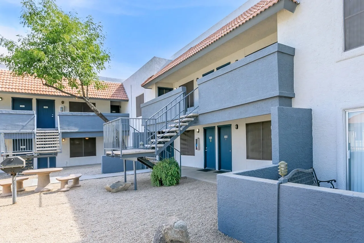 Courtyard with blue accent walls, metal staircase, gravel flooring, architectural plants, Glendale