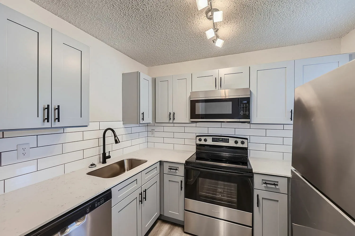Kitchen, white shaker cabinetry, quartz countertops, stainless steel appliances, subway tile backsplash