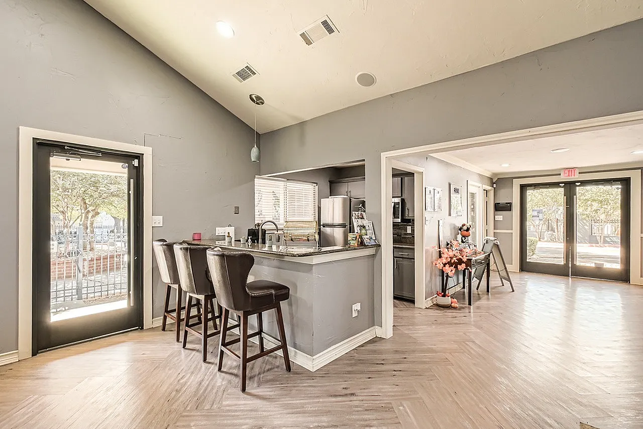 Kitchen and dining area, gray cabinetry, stainless appliances, island with seating, wood-style plank flooring