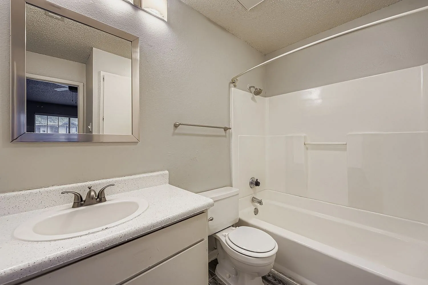 Primary bathroom, white vanity sink, quartz countertop, mirrored medicine cabinet, white subway tile shower surround, toilet