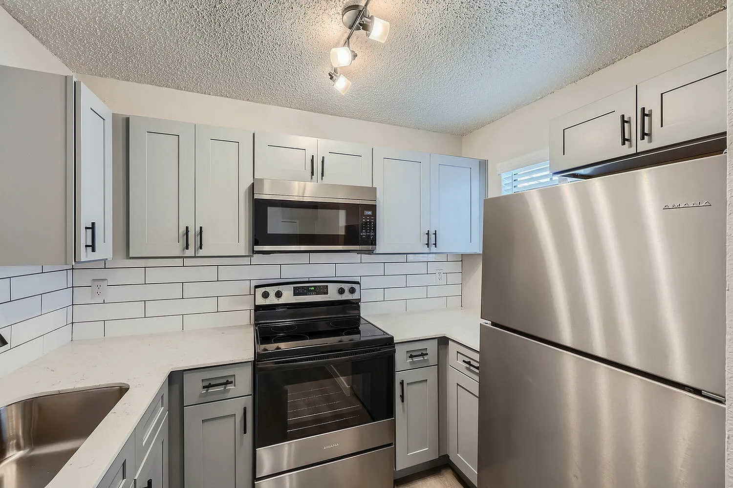 Kitchen, white shaker cabinetry, quartz countertops, stainless steel appliances, subway tile backsplash