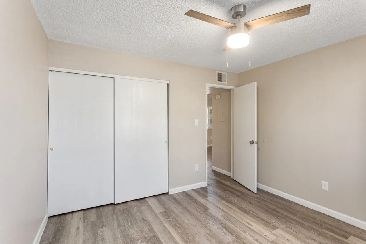Bedroom, wood-style plank flooring, ceiling fan with light, dual closets, neutral paint