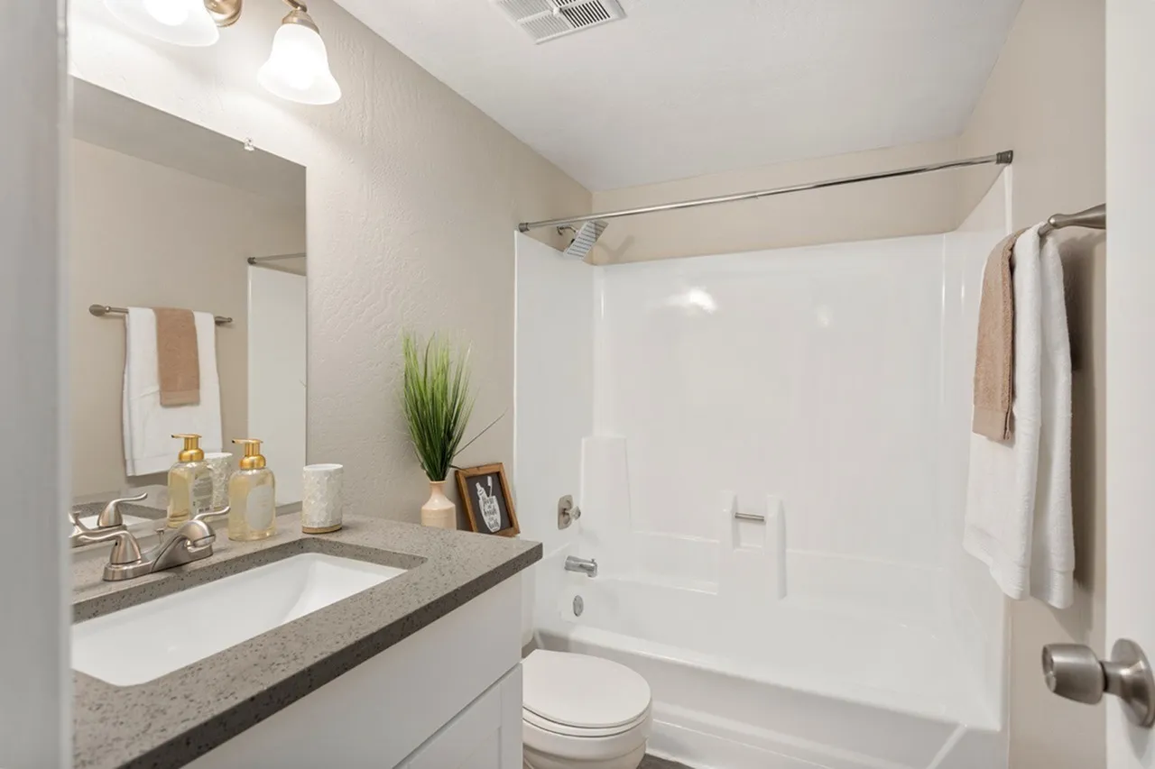 Primary bathroom, quartz countertops, undermount sink, white tile shower surround