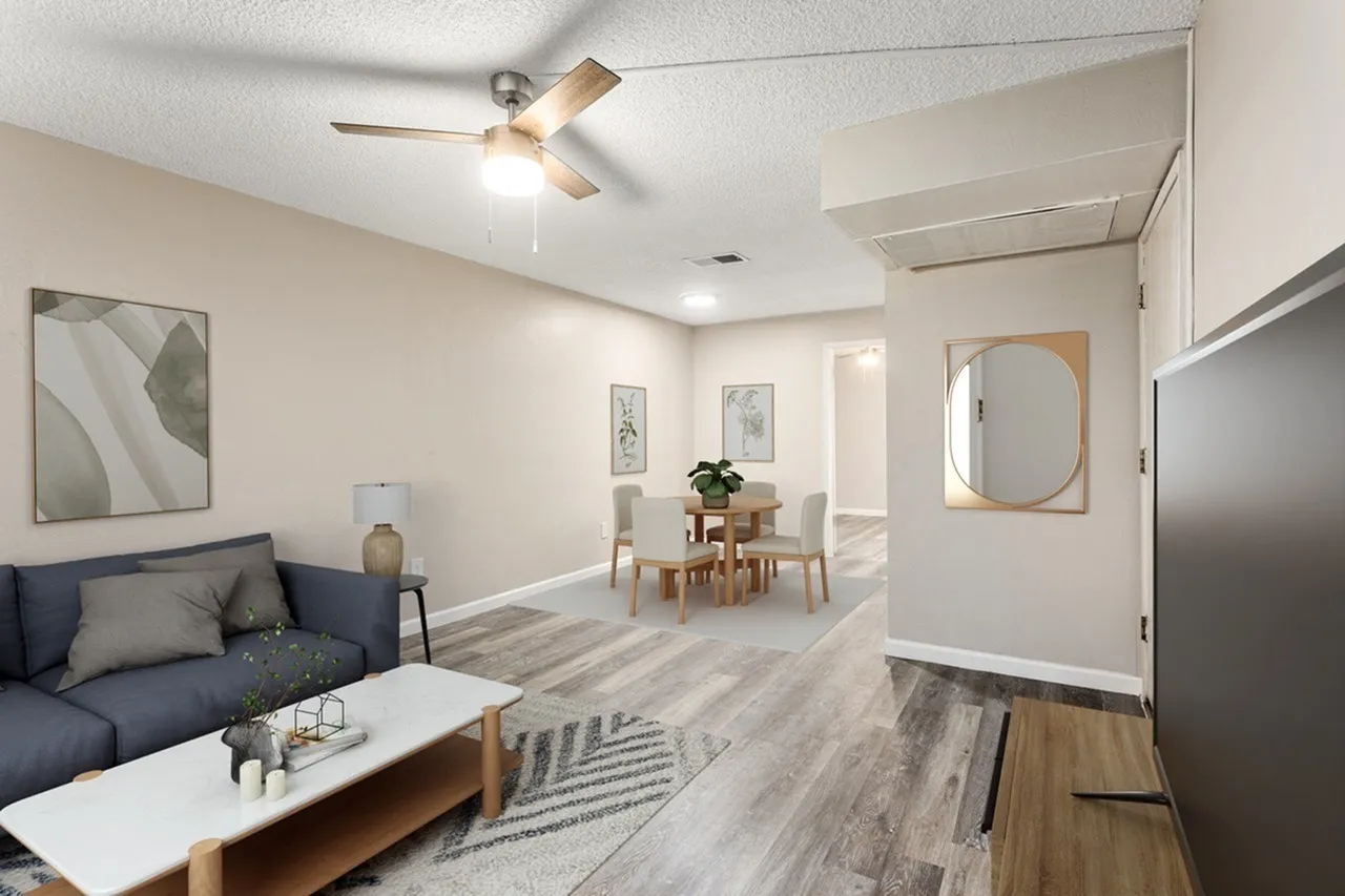 Living room and dining area, wood-style plank flooring, ceiling fan, gray upholstered sofa