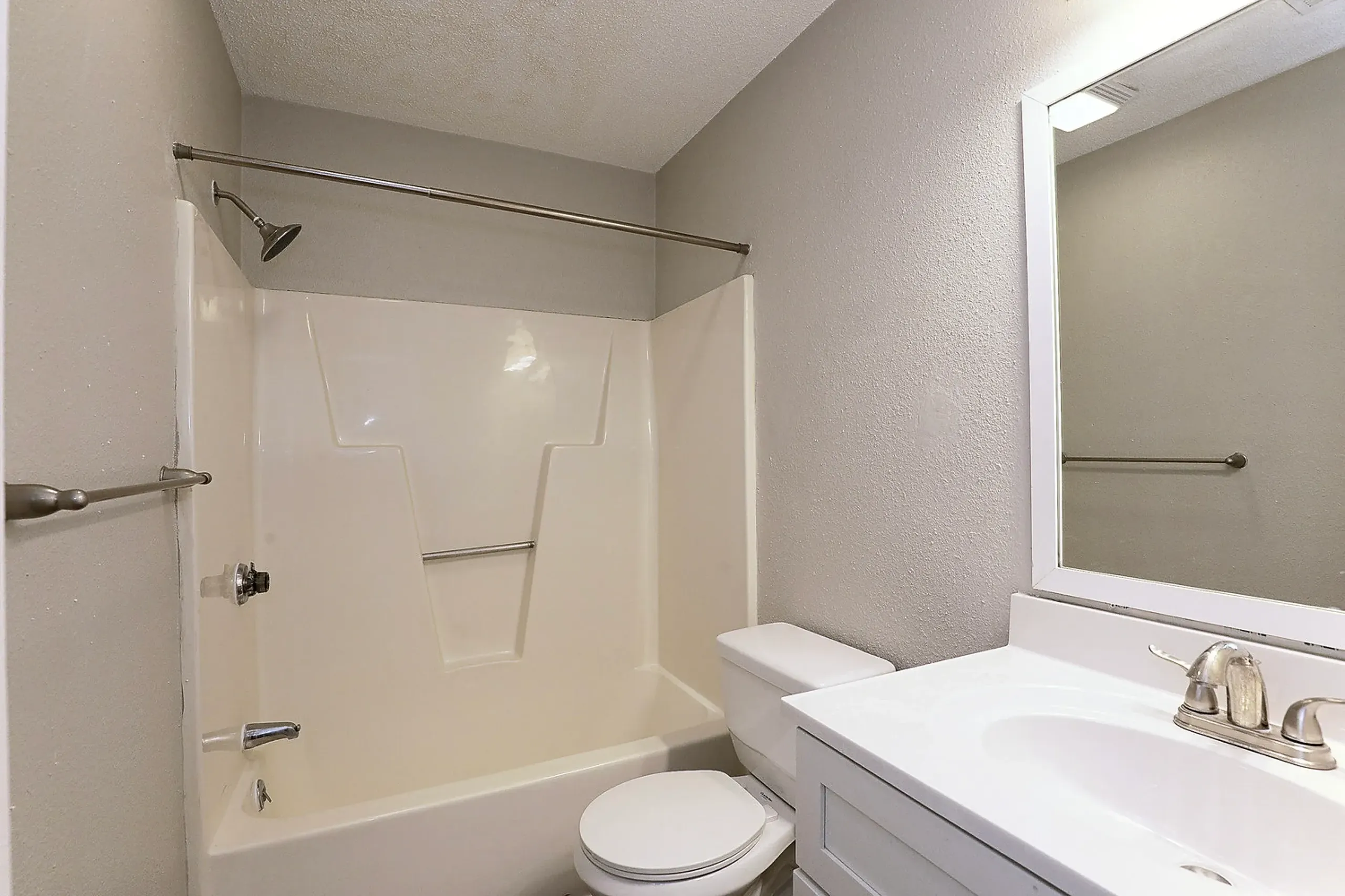 Bathroom, white dual vanity sink, mirror with lighting, shower enclosure