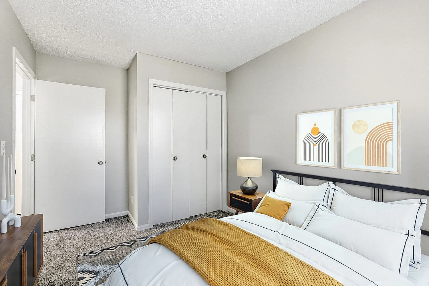 Primary bedroom, wood-style plank flooring, dual closets, yellow accent bedding