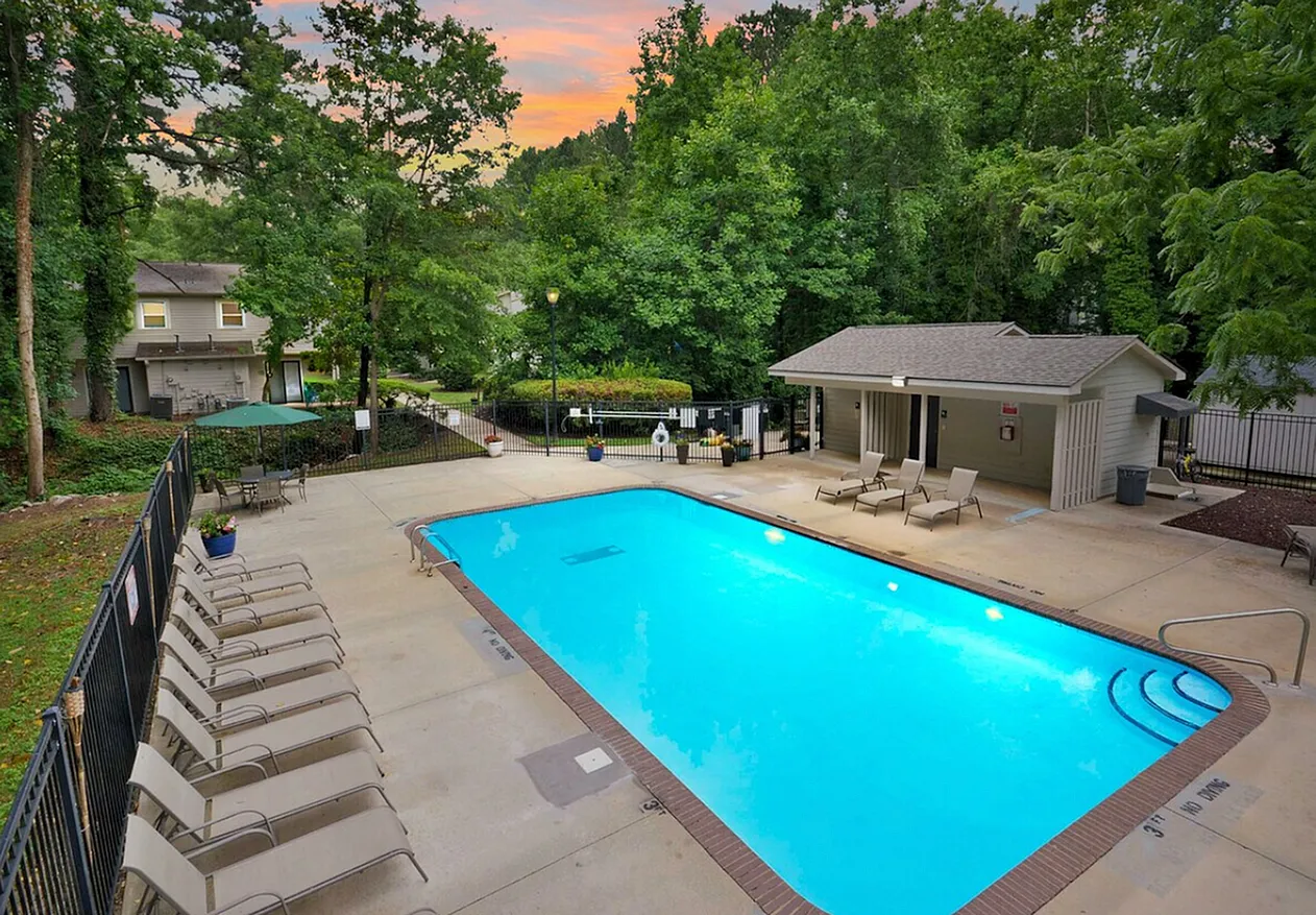 Resort-style pool, lounge seating, pavilion, wooded grounds