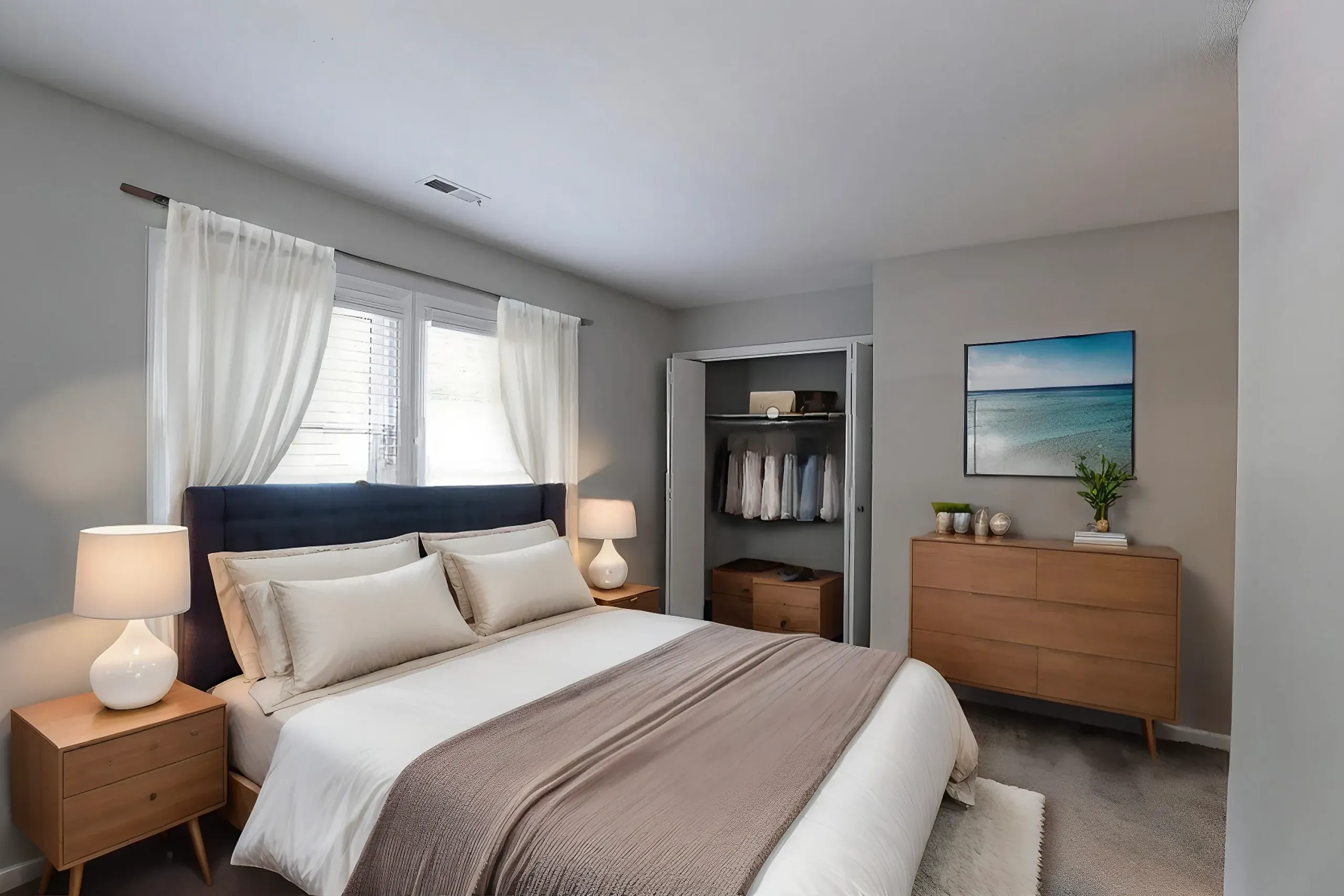 Primary bedroom, wood-style plank flooring, dark upholstered headboard, wood nightstands, round table lamps
