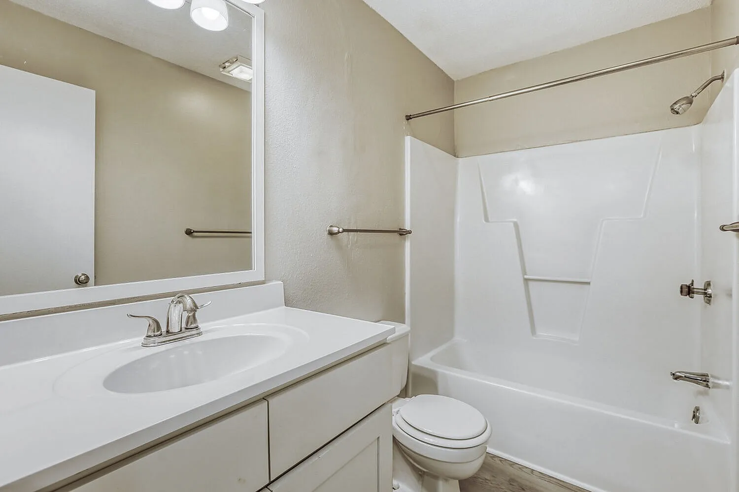 Primary bathroom, white vanity sink, large mirror, white subway tile shower