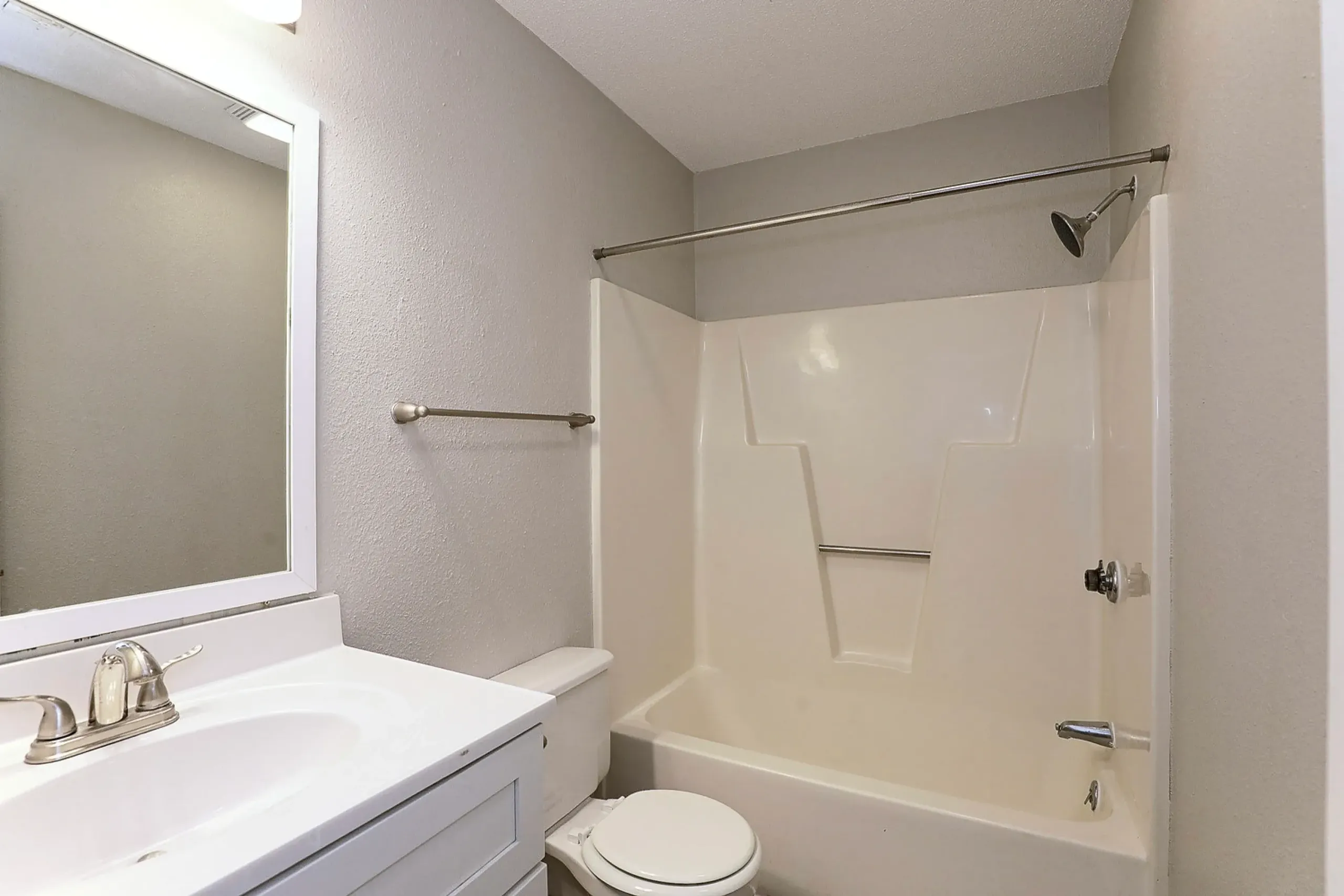 Bathroom, white vanity with mirror, toilet, fiberglass tub shower combo