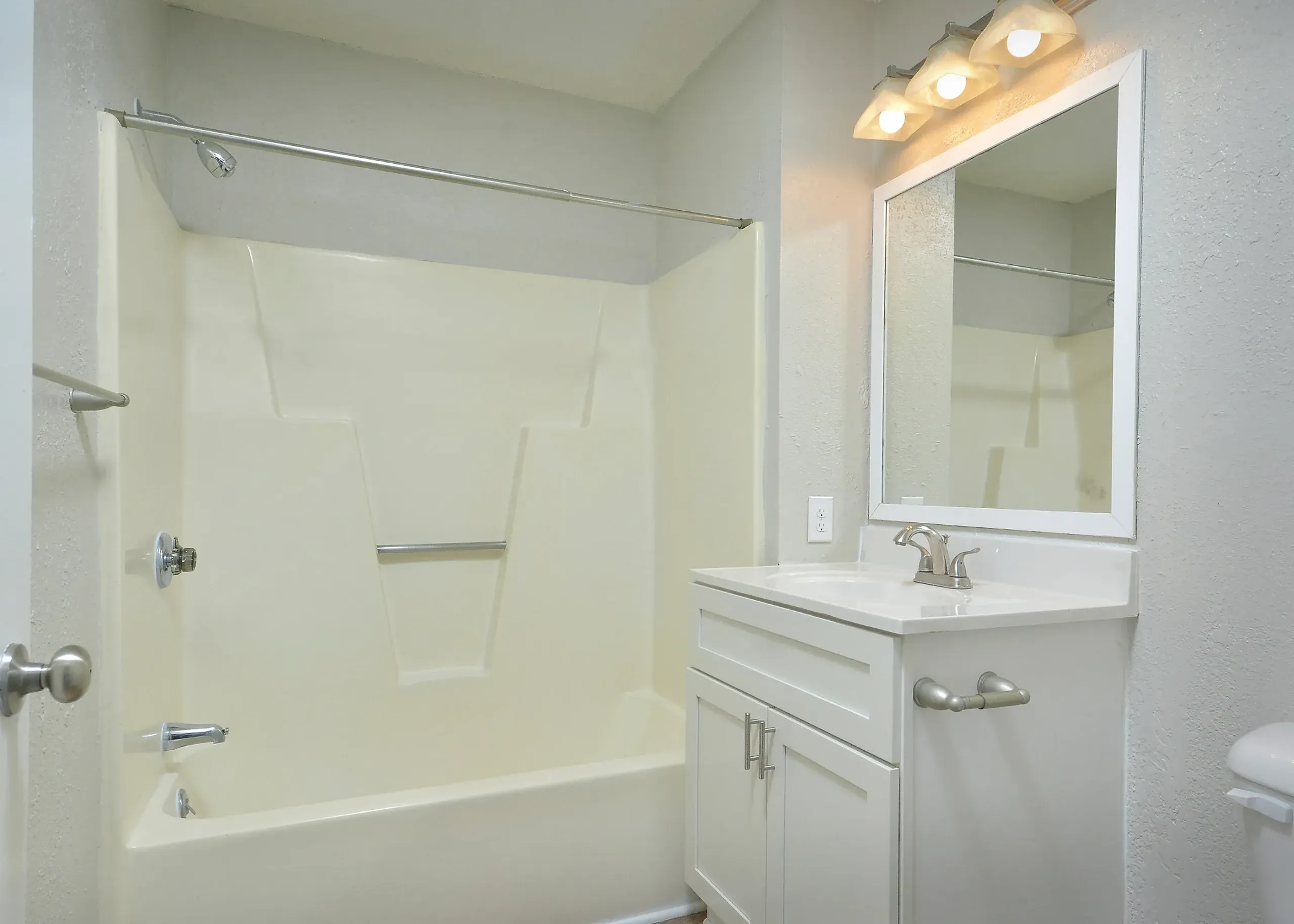 Bathroom, white vanity with sink, framed mirror with lights, shower tub combo